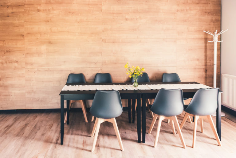 Pasieka Smakulskich - noclegi - zdjęcia wnętrz (Pokoje na 1 piętrze) - stół z siedmioma krzesłami na tle ściany z drewnianych płyt