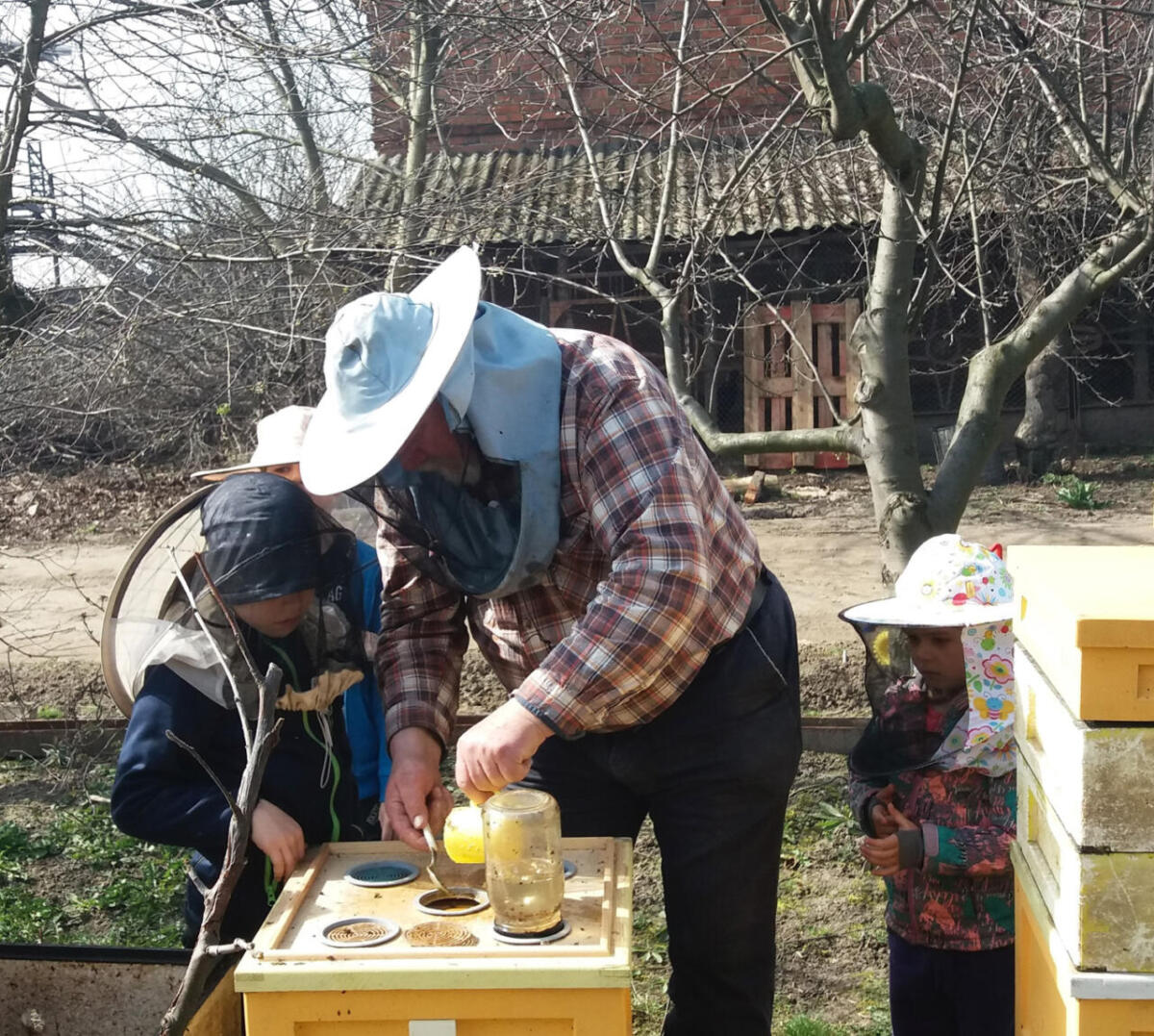 Pasieka Smakulskich - działalność edukacyjna - pszczelarz pokazuje rzemiosło dzieciom