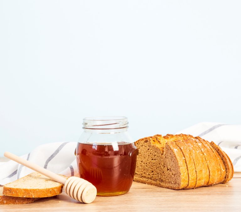 miód skrystalizowany gorszy niż miód płynny - pasieka smakulskich, wielkopolska, dolina baryczy, rawicz, leszno, pakosław, miód, sklep, słoik miodu i chleb leżący na stole